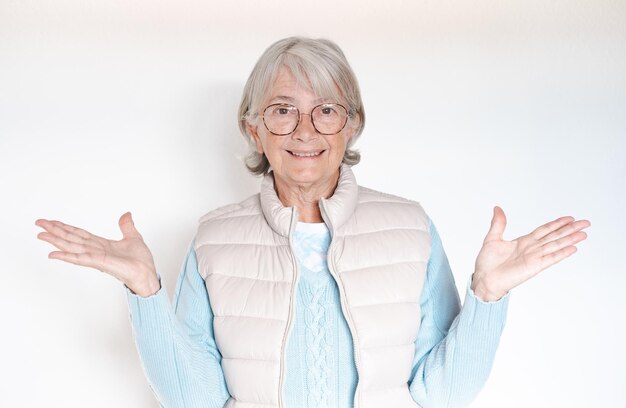 Portrait attraktive Seniorin mit Brille, die in die Kamera blickt und mit den Händen auf Weiß gestikuliert