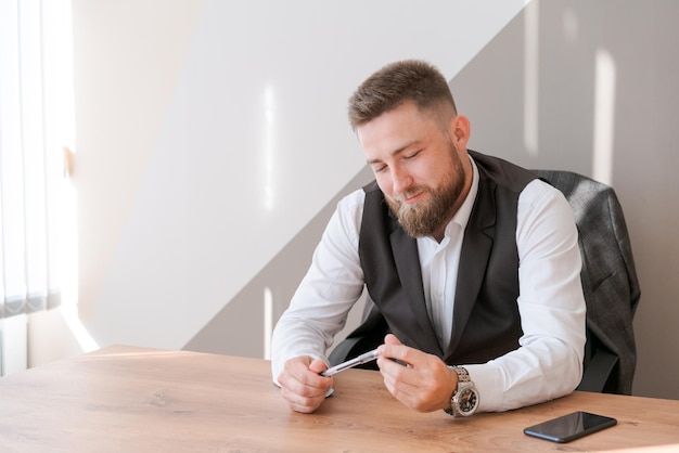 Portrait bärtiger Geschäftsmann sitzt im Büro und meditiert mit Stift in seinem