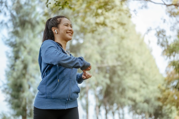 Portrait das asiatische Mädchen trainiert bei den Wochenendübungen und streckt ihren Körper in der Natur