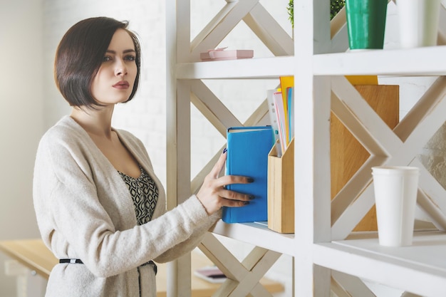 Portrait der attraktiven Frau, die Bücher hält