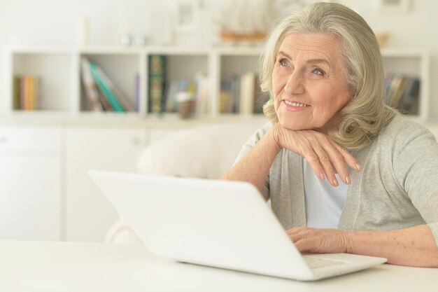 Portrait der glücklichen älteren Frau, die Laptop verwendet