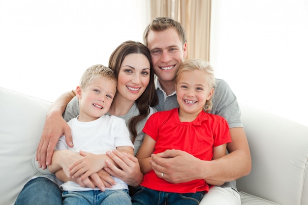 Portrait der glücklichen Familie sitzend auf Sofa