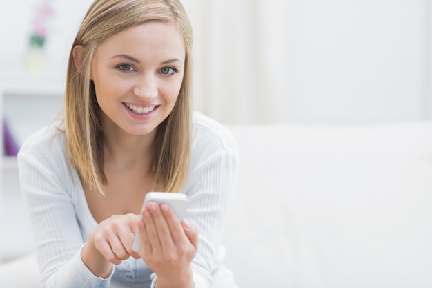 Portrait der glücklichen Frau mit Handy zu Hause