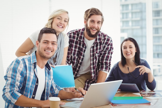 Portrait der glücklichen Geschäftsleute, die an Laptop arbeiten