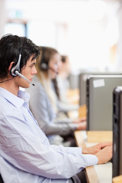 Portrait der jungen Bediener, die einen Computer verwenden