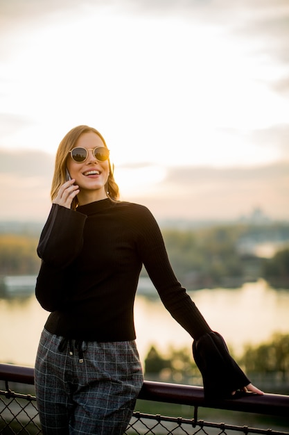 Portrait der jungen Frau mit dem Handy im Freien