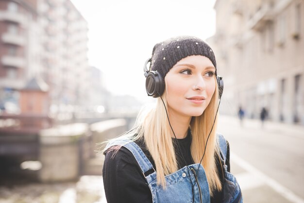 Portrait der jungen schönen blonden Frau des geraden Haares in der Stadt