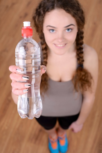 Portrait der jungen schönen Frau mit Flasche Wasser.