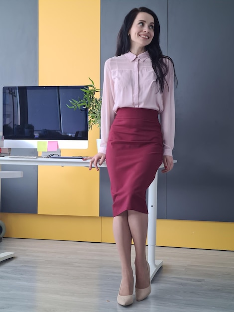 Portrait der lächelnden Geschäftsfrau, die im Büro steht