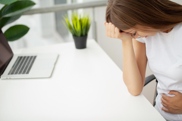 Portrait der müden jungen Geschäftsfrau mit Laptop-Computer