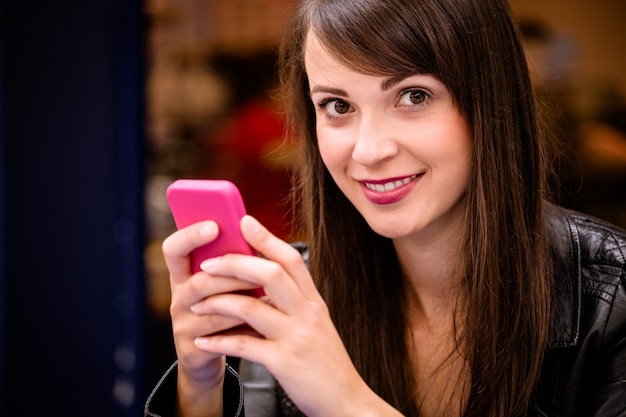 Portrait der schönen Frau, die Handy verwendet