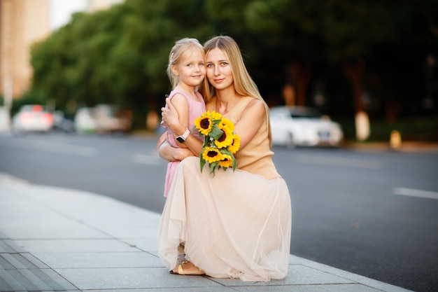 Portrait der schönen Frau und des Mädchens mit Sonnenblumen