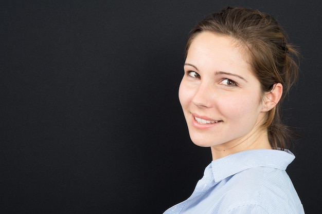 Portrait der schönen jungen Frau auf schwarzem Hintergrund