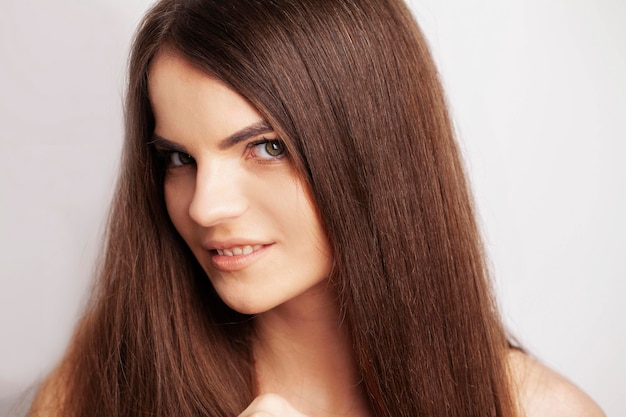 Portrait der schönen jungen Frau mit dem langen braunen Haar.