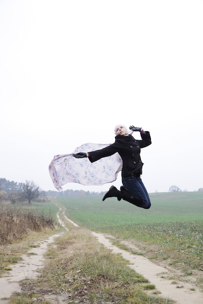 Portrait der springenden jungen blonden Frau