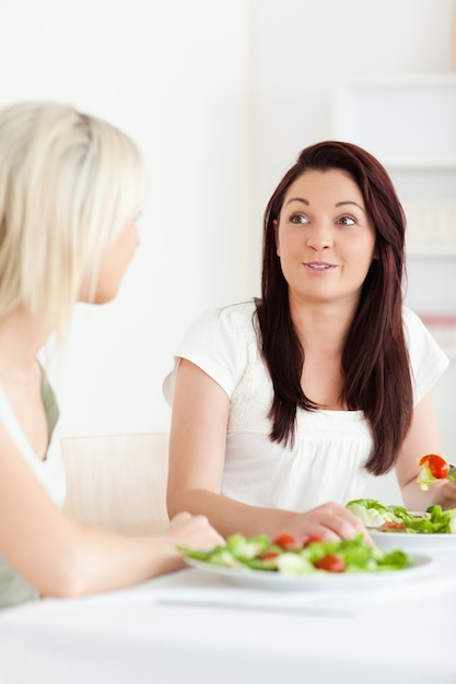 Portrait der überraschten Frauen, die Salat essen