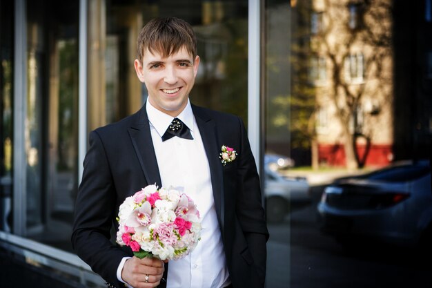 Portrait des Bräutigams mit einem Hochzeitsbrautblumenstrauß