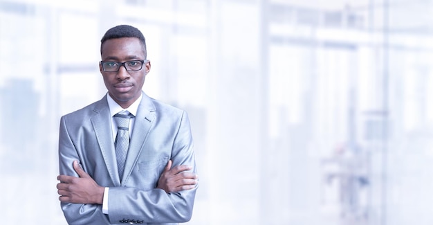 Portrait des jungen Juniorgeschäftsmannes vor seinem großen modernen Büro