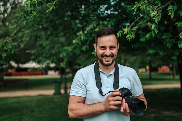 Portrait des männlichen Fotografen. Nahansicht. Kamera betrachten.