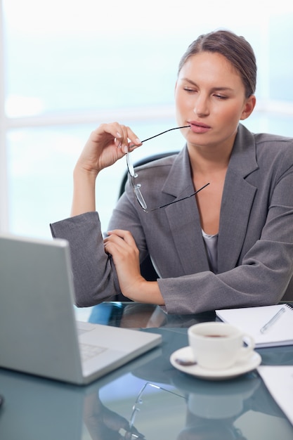 Portrait einer durchdachten Geschäftsfrau, die einen Laptop verwendet