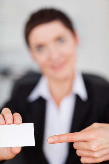 Foto portrait einer frau, die eine unbelegte visitenkarte zeigt