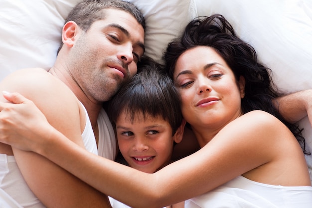 Portrait einer glücklichen Familie, die im Bett schläft