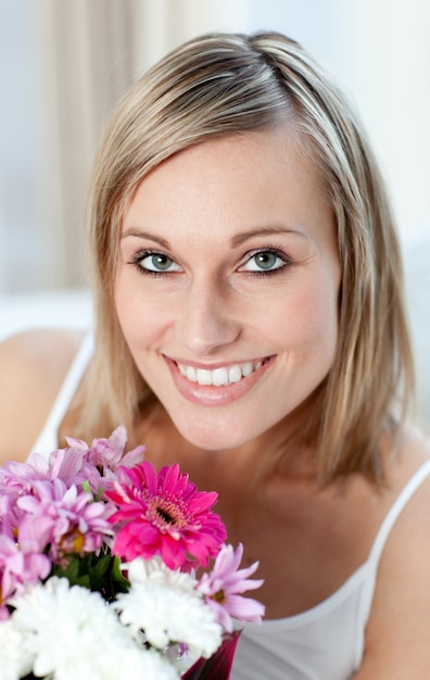 Portrait einer glücklichen Frau, die einen Blumenstrauß anhält