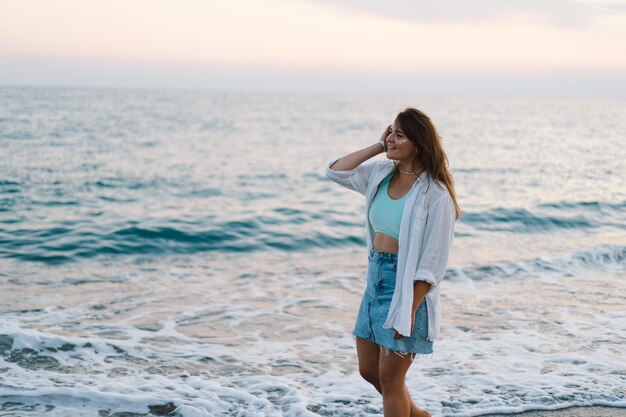 Portrait einer glücklichen jungen Frau auf einem Hintergrund des schönen Meeres