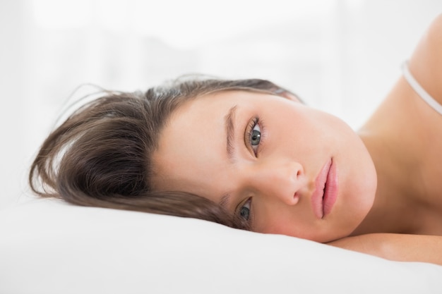 Portrait einer hübschen jungen Frau im Bett