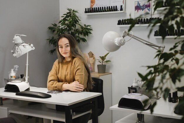 Portrait einer jungen Brünettin, die im Nagelsalon wartet