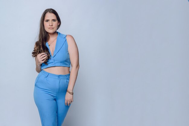 Portrait einer jungen, ermächtigten, unternehmerischen lateinamerikanischen Frau, die in blauen Kleidern posiert