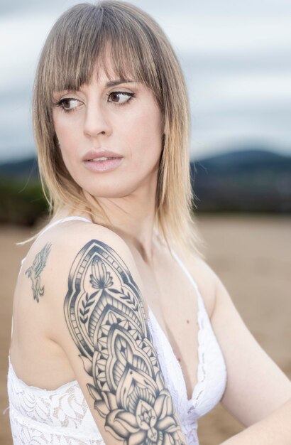 Foto portrait einer jungen frau, die am strand sitzt