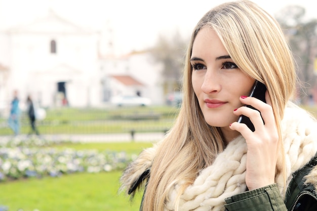 Foto portrait einer jungen frau, die am telefon spricht