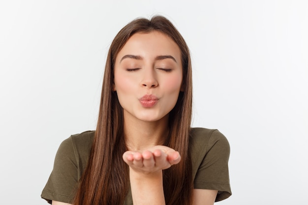 Portrait einer jungen Frau, die einen Kuss getrennt über Weiß durchbrennt.