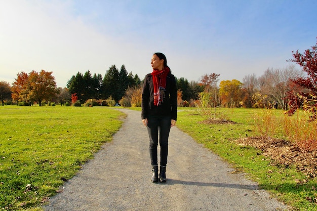 Foto portrait einer jungen frau in voller länge, die auf dem feld steht