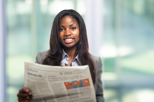 Portrait einer jungen Geschäftsfrau, die eine Zeitung liest