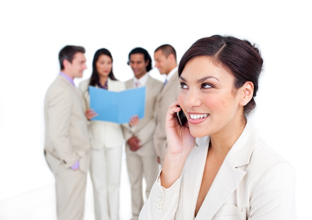 Portrait einer lachenden Geschäftsfrau am Telefon mit ihrem Team