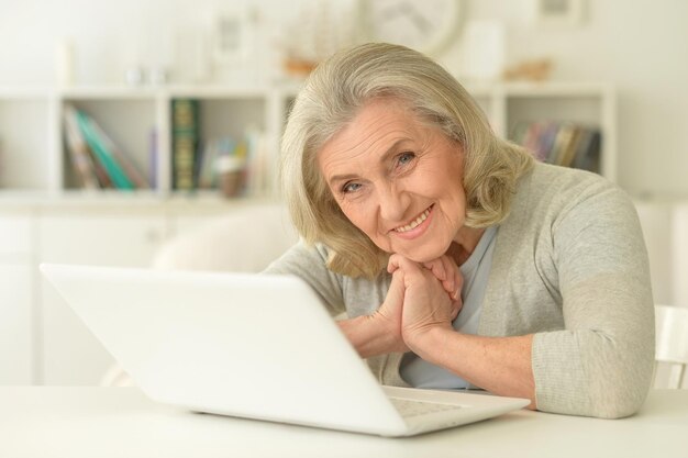 Portrait einer lächelnden älteren Frau, die Laptop verwendet