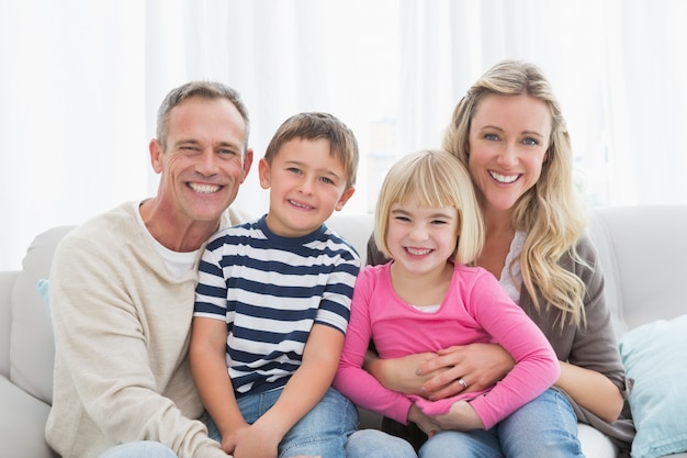 Portrait einer lächelnden Familie, die auf Sofa sitzt