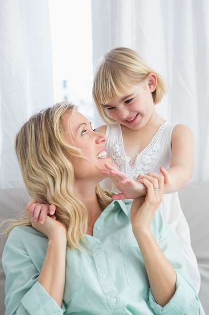 Portrait einer Mutter und Tochter hinter ihr auf der Couch