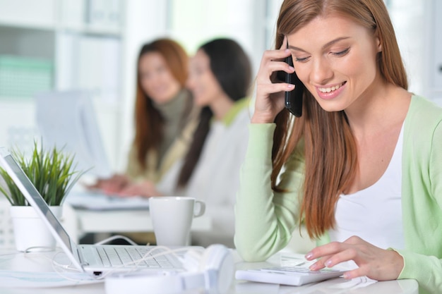 Portrait einer netten Geschäftsfrau mit Laptop im Büro