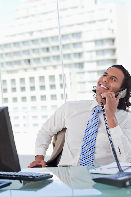 Portrait eines begeisterten Geschäftsmannes am Telefon