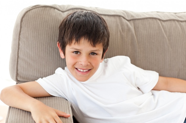 Portrait eines entzückenden Kindes, das auf dem Sofa sich entspannt