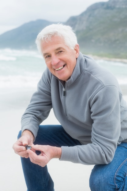 Portrait eines glücklichen älteren Mannes, der am Strand sich entspannt