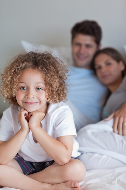 Portrait eines Jungen, der auf dem Bett seiner Eltern sitzt