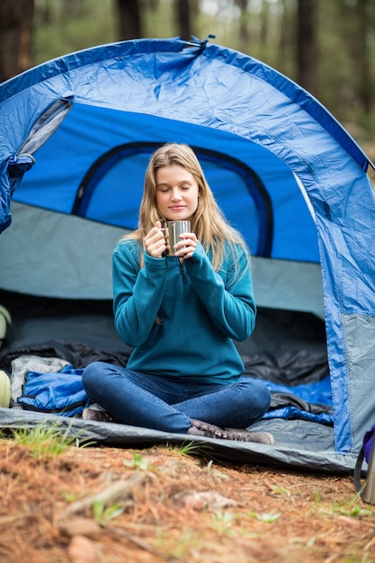 Portrait eines jungen hübschen Wanderers, der in einem Zelt sitzt