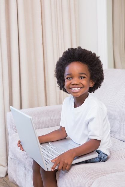 Portrait eines kleinen Jungen, der einen Laptop verwendet