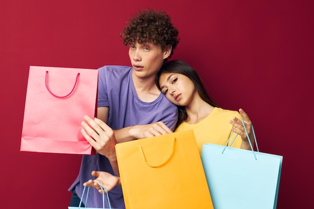 Portrait eines Mannes und einer Frau in bunten T-Shirts mit Taschen Shopping Lifestyle unverändert
