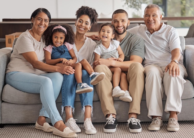 Portrait Familienkinder entspannen sich und Großeltern glücklich auf dem Sofa im Wohnzimmer im Haus während des Ruhestands Mutter Vater und junge Mädchen Kinder auf der Couch mit einem Lächeln und älteren Menschen für eine schöne Zeit