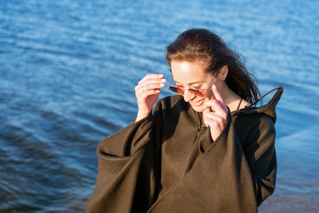 Portrait glücklich lächelnde Frau am Strand Lächelnde sinnliche Brunetteaufstellung